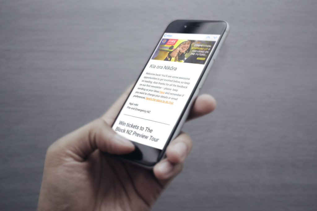 FENZ-edm-iphone-hand Hand holding a phone displaying a mobile-optimised EDM example by communication strategists Wonderlab