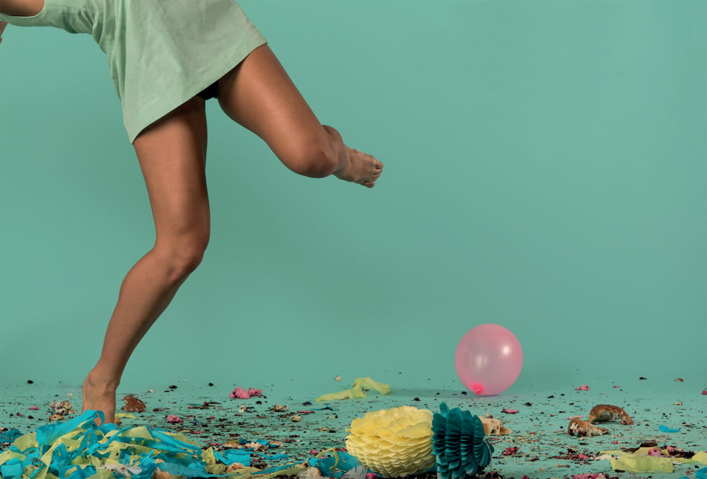Now 2016 NEW A woman jumping in front of confetti and balloons.