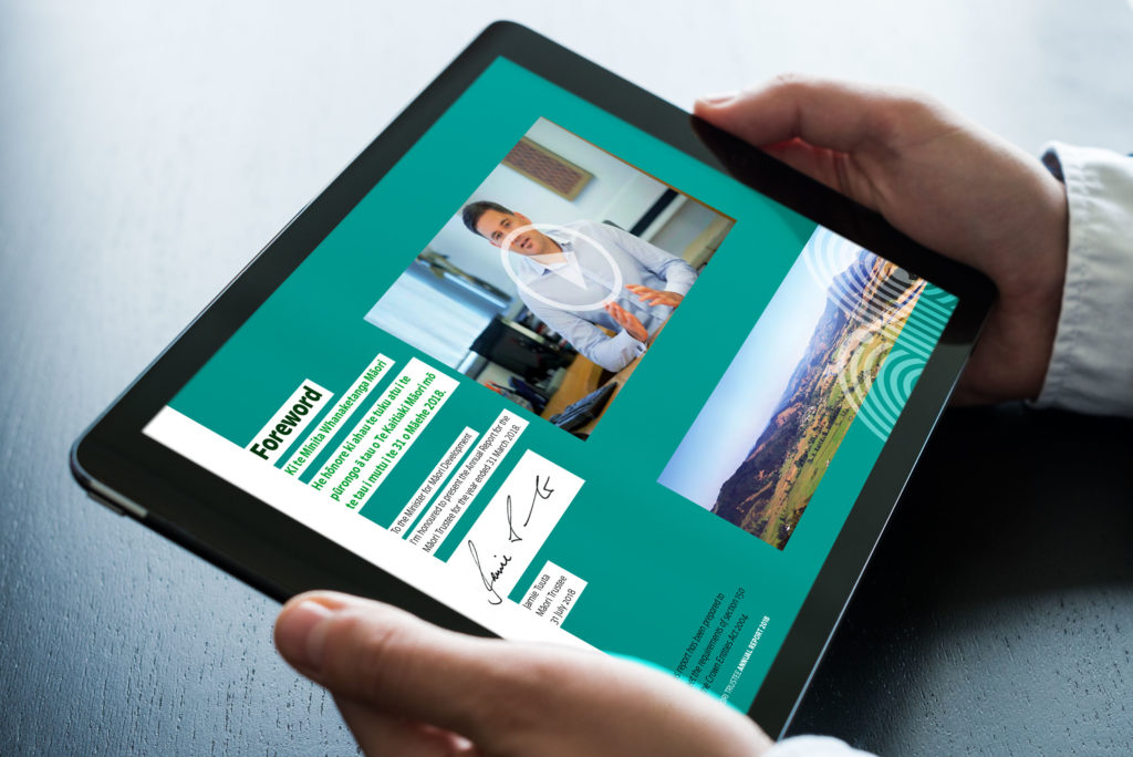 TTP_Annual-Report-2018_Spread-1_tablet A person holding a tablet with a picture of a person on it.