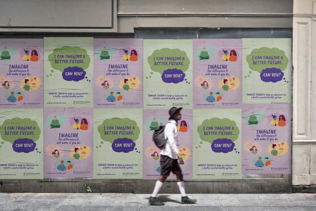 MHF-Wall Poster Mockup_1-0 A man walking past a building with the Mental Health Foundation's advocacy campaign posters on it.
