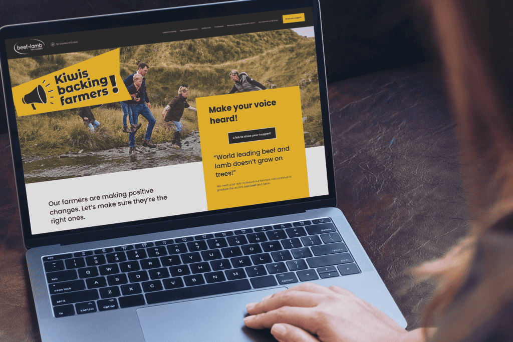 Beef & Lamb laptop woman A person views a Beef & Lamb website on a laptop, displaying a banner with "Kiwis backing farmers!" and an image of people working in a field. The site encourages support for farmers, with text urging readers to "Make your voice heard!" and mentions "world leading beef and lamb.