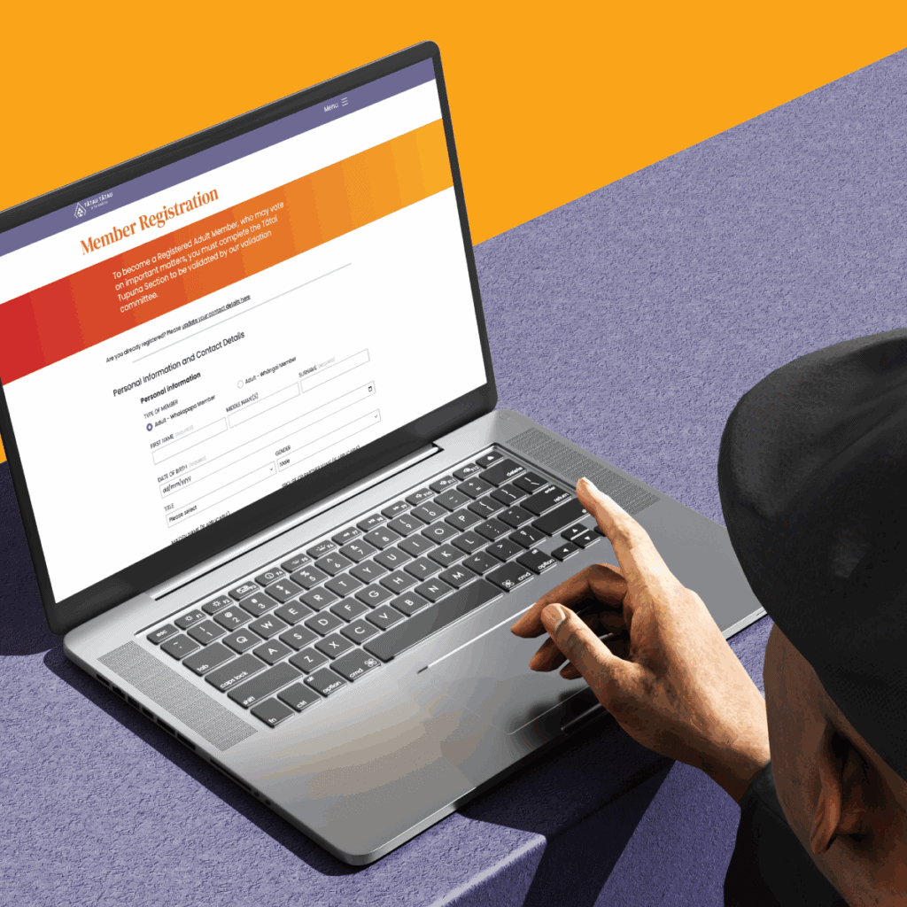 TToTW_PortfolioArtboard-1-copy-6 A person using a laptop on a purple surface is filling out an online member registration form with fields for name, address, and contact details. The background is a solid yellow-orange color.